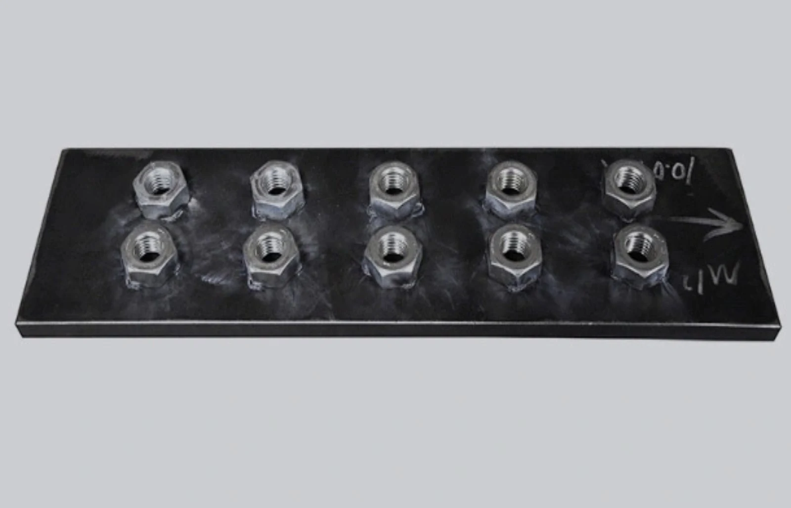 Ten nuts welded in two rows on a black coated steel plate.
